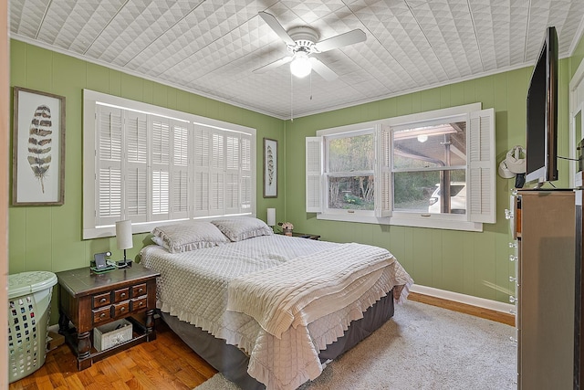 bedroom with ornamental molding, wood finished floors, and ceiling fan