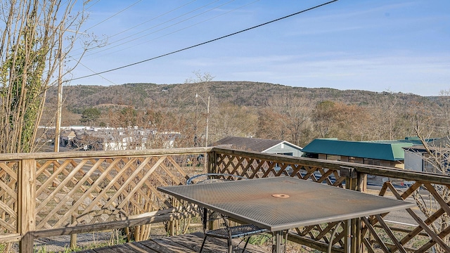 wooden terrace featuring a view of trees