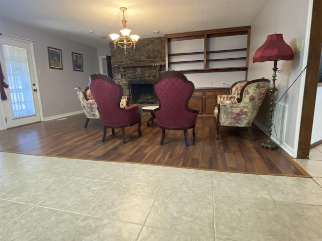 dining space with visible vents, a notable chandelier, a textured ceiling, wood finished floors, and baseboards