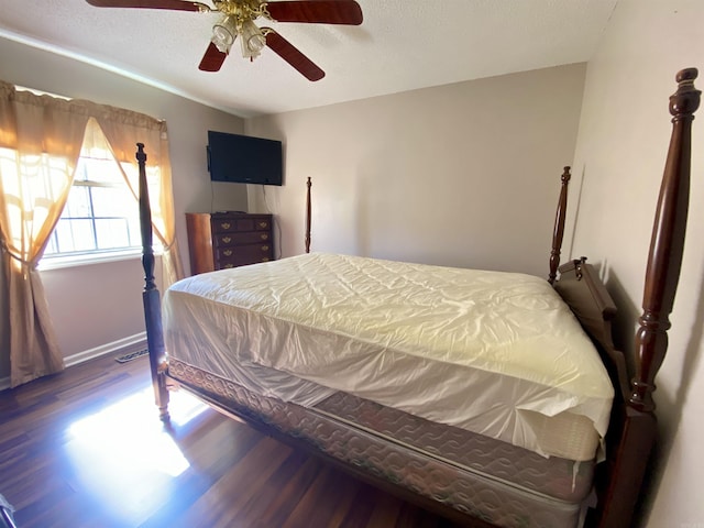 bedroom with baseboards, a textured ceiling, a ceiling fan, and wood finished floors