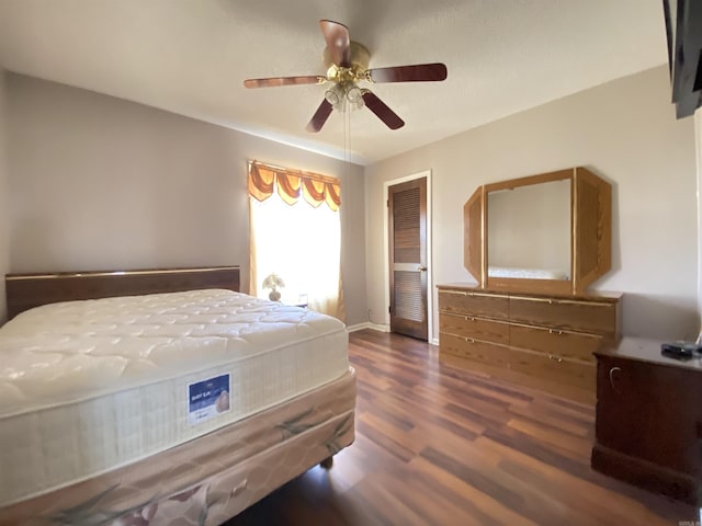 bedroom featuring ceiling fan, a closet, baseboards, and wood finished floors