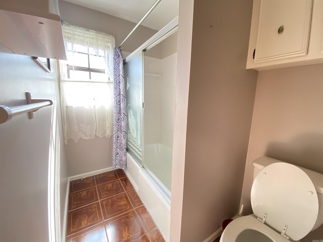 full bath featuring tile patterned flooring, toilet, baseboards, and shower / bath combo