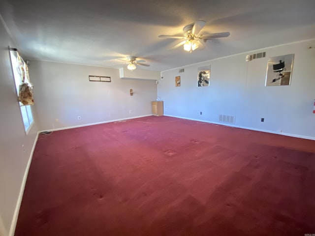 carpeted empty room featuring visible vents, baseboards, a ceiling fan, and ornamental molding