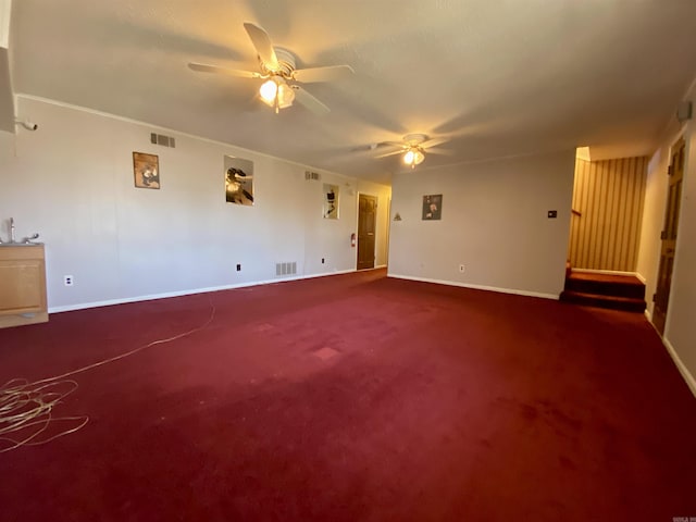 carpeted spare room featuring a ceiling fan, visible vents, and baseboards