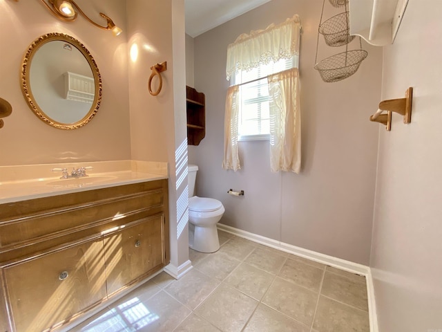 bathroom featuring tile patterned flooring, toilet, vanity, and baseboards