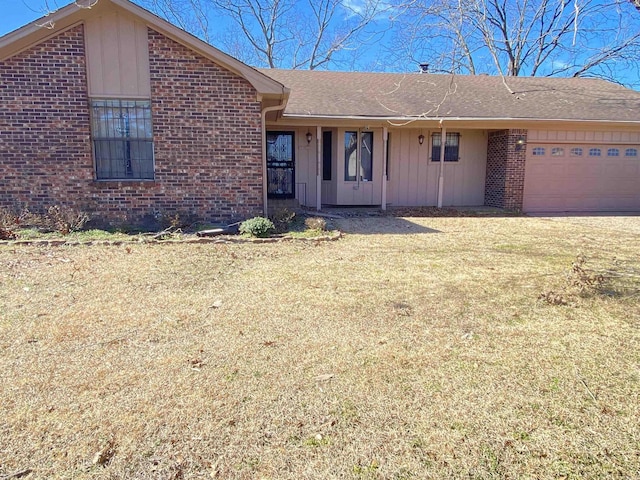 single story home with a garage, brick siding, and a front yard