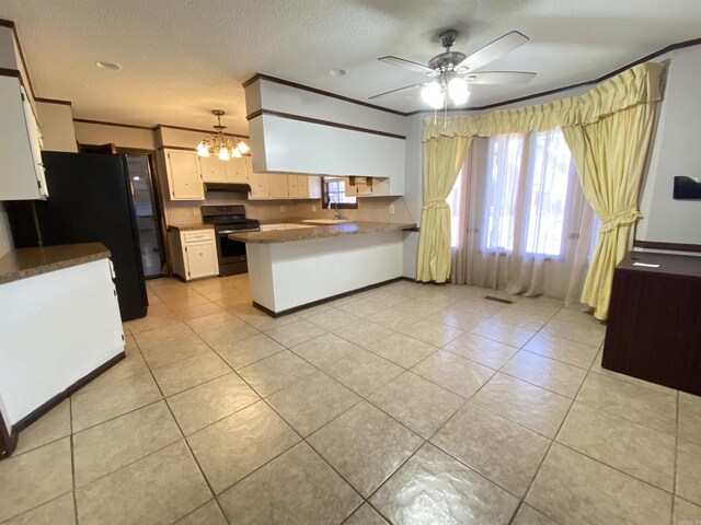 kitchen featuring a peninsula, stainless steel range with electric stovetop, crown molding, and freestanding refrigerator