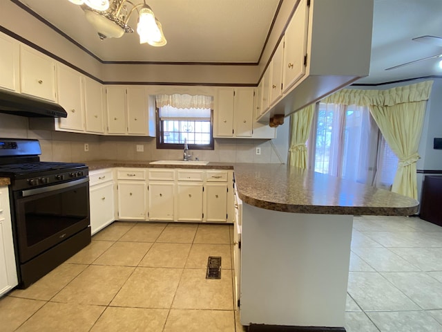 kitchen with light tile patterned floors, a peninsula, a sink, under cabinet range hood, and stainless steel gas range oven