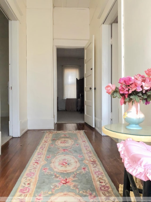 hallway with baseboards and wood finished floors