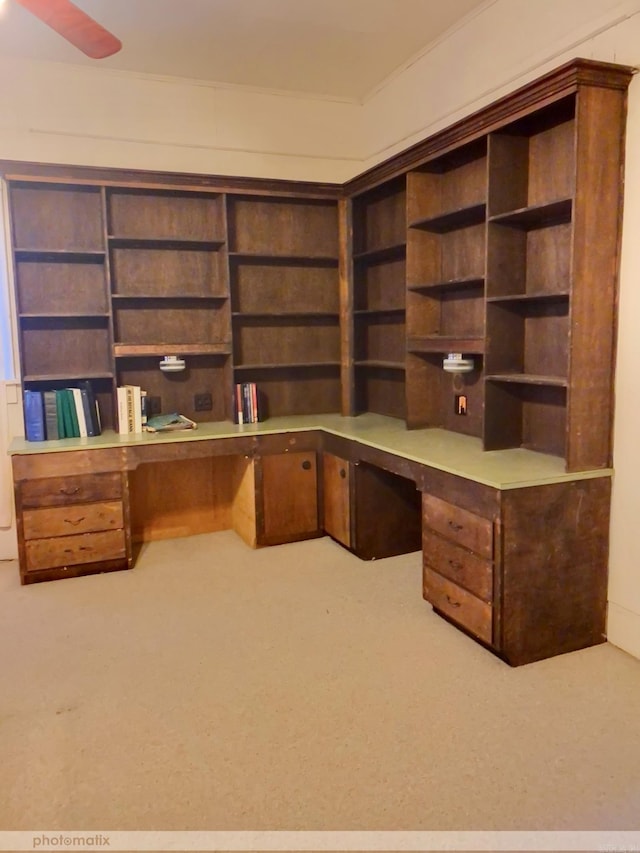 unfurnished office featuring ceiling fan, carpet, and built in study area