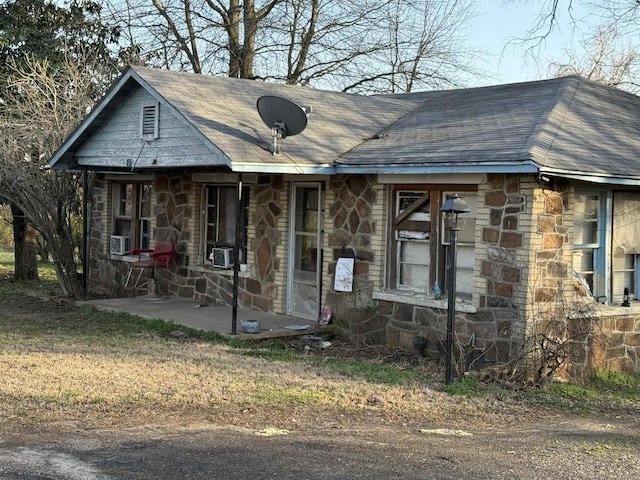 view of front of house with stone siding and a shingled roof