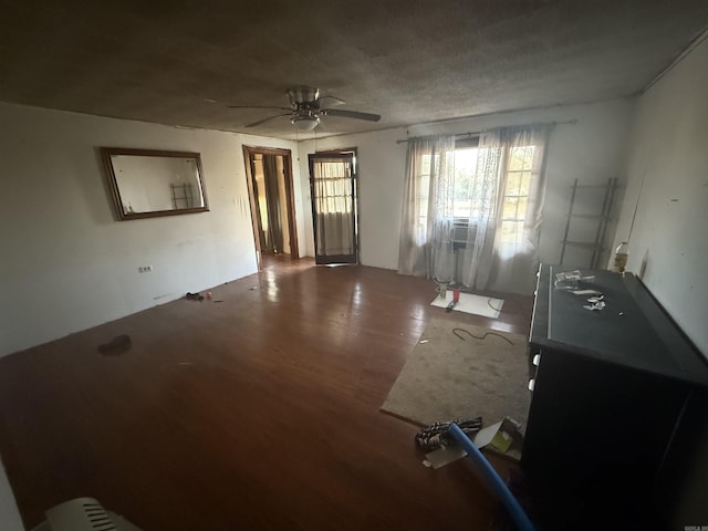 unfurnished living room featuring wood finished floors, a textured ceiling, and ceiling fan