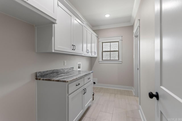 washroom featuring cabinet space, baseboards, and washer hookup