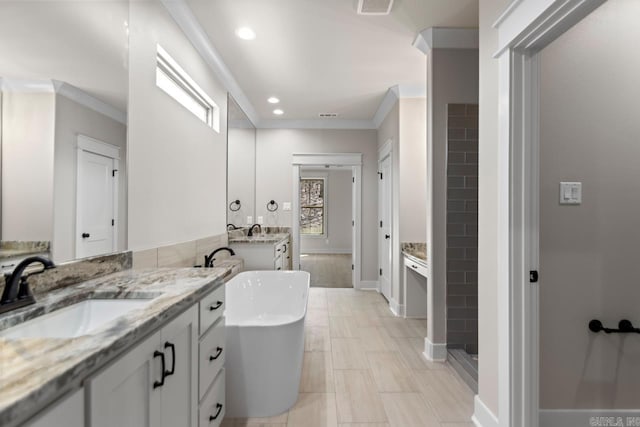 bathroom with two vanities, ornamental molding, a sink, recessed lighting, and a soaking tub