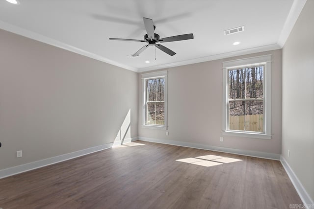 unfurnished room with visible vents, ornamental molding, a ceiling fan, wood finished floors, and baseboards