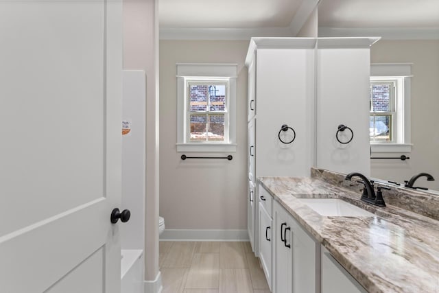 full bath with vanity, toilet, plenty of natural light, and baseboards