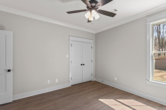 interior space with a wealth of natural light, visible vents, wood finished floors, and ornamental molding