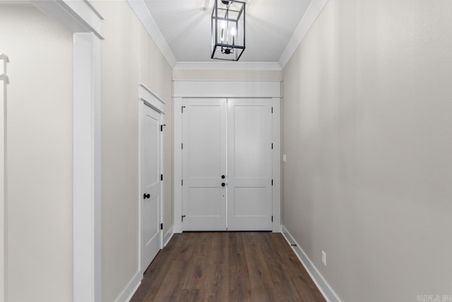 entryway with dark wood finished floors, baseboards, and ornamental molding