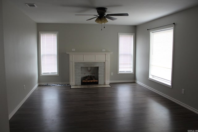 unfurnished living room featuring visible vents, dark wood finished floors, a fireplace, baseboards, and ceiling fan