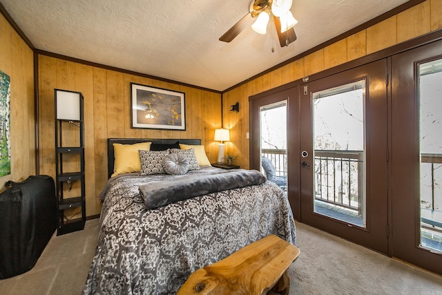 carpeted bedroom with access to exterior, a textured ceiling, french doors, crown molding, and ceiling fan