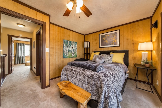 bedroom featuring light carpet, wooden walls, a textured ceiling, and ornamental molding