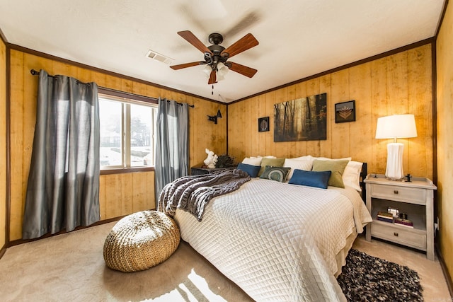 bedroom featuring visible vents, wooden walls, ornamental molding, light carpet, and a ceiling fan