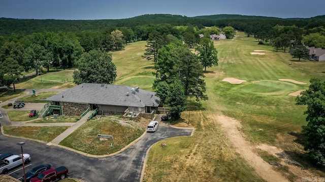 birds eye view of property with golf course view and a forest view