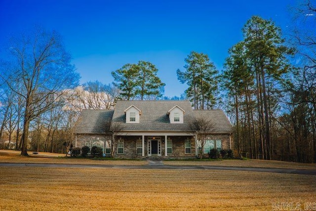 cape cod home featuring a front lawn