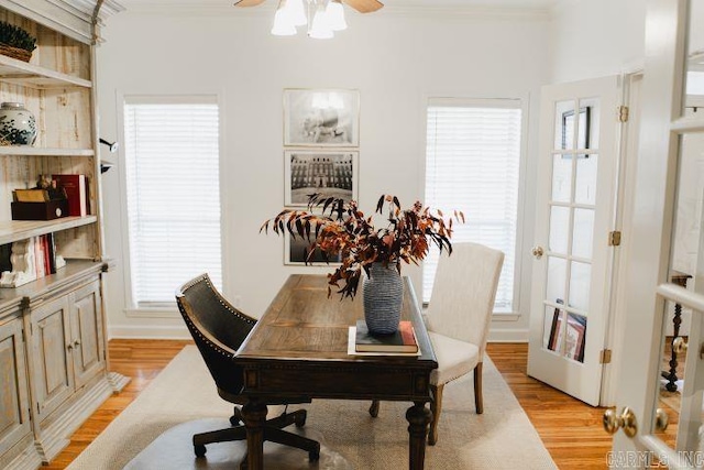 office space featuring crown molding, light wood finished floors, and ceiling fan