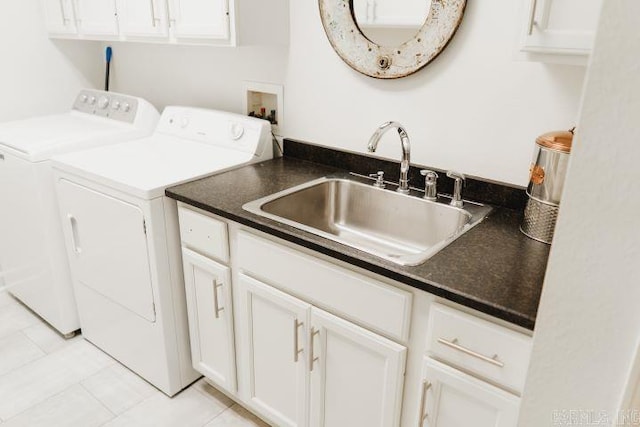 laundry area with separate washer and dryer, light tile patterned floors, cabinet space, and a sink