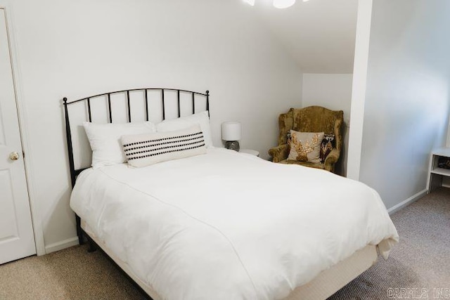 carpeted bedroom featuring lofted ceiling and baseboards