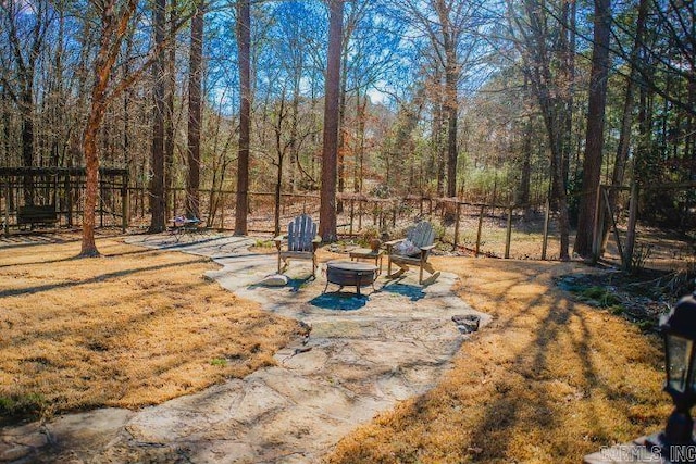 view of yard with fence, a fire pit, and a patio area