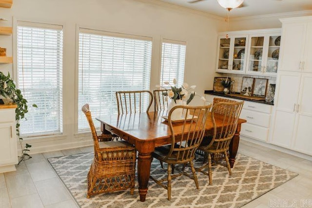 dining room featuring crown molding, light tile patterned floors, and ceiling fan