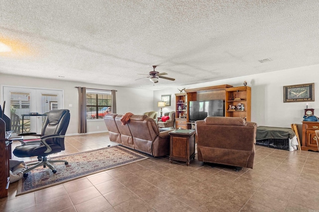 living area featuring tile patterned flooring, visible vents, a textured ceiling, and ceiling fan