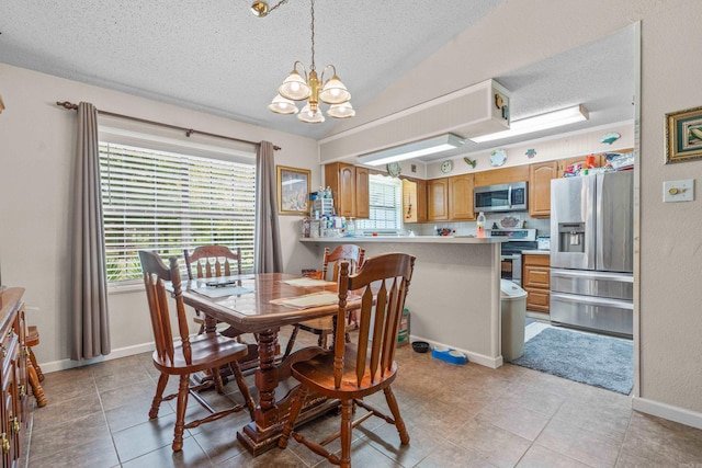 dining space with a chandelier, a textured ceiling, baseboards, and vaulted ceiling