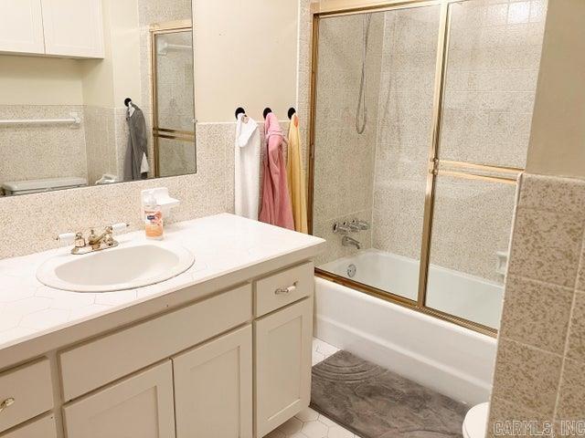 full bathroom with vanity, toilet, and bath / shower combo with glass door