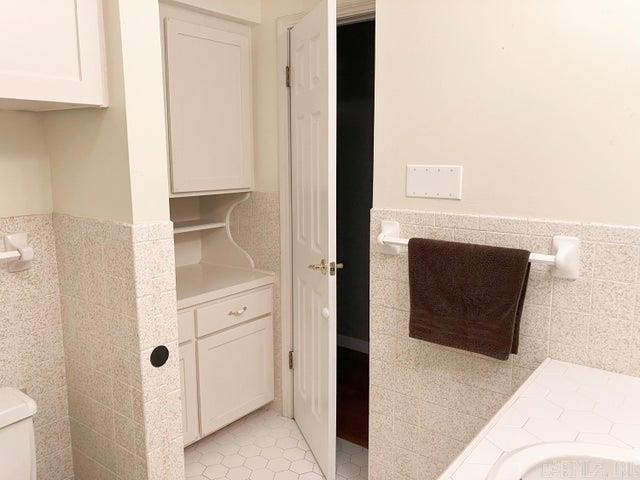 bathroom with tile patterned flooring, wainscoting, tile walls, and toilet