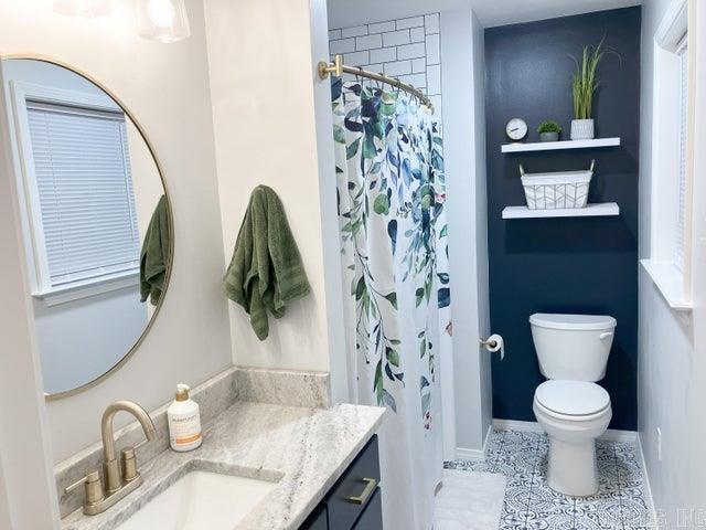 bathroom with vanity, a shower with shower curtain, baseboards, tile patterned flooring, and toilet