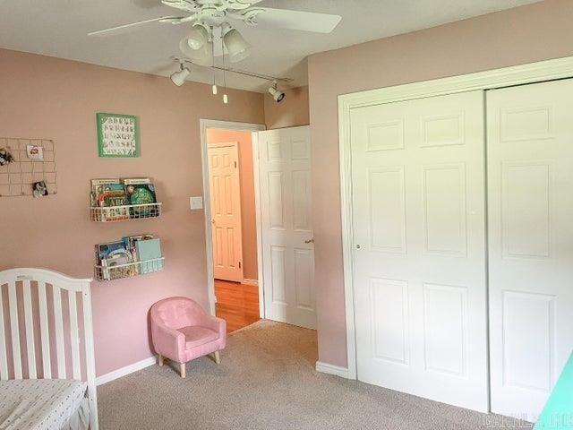 unfurnished bedroom with ceiling fan, baseboards, carpet floors, rail lighting, and a closet