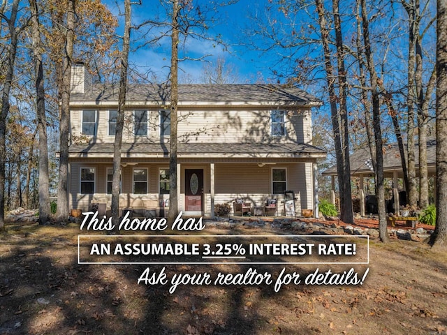 rear view of property with a porch, a chimney, and a shingled roof