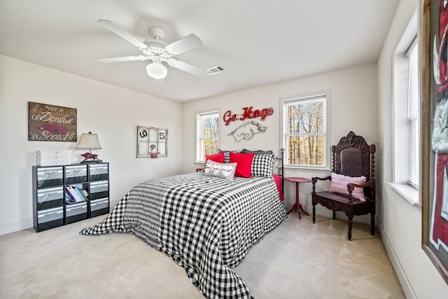 bedroom featuring visible vents, multiple windows, a ceiling fan, and carpet