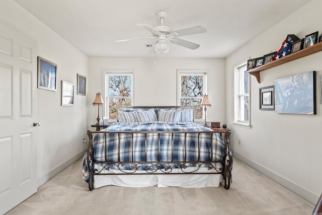 bedroom with light carpet, multiple windows, and baseboards