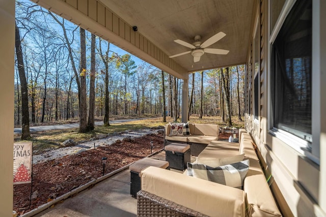 view of patio / terrace with an outdoor hangout area, a view of trees, and a ceiling fan