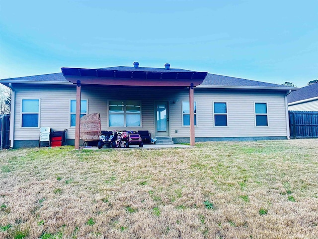 rear view of house with a yard and fence