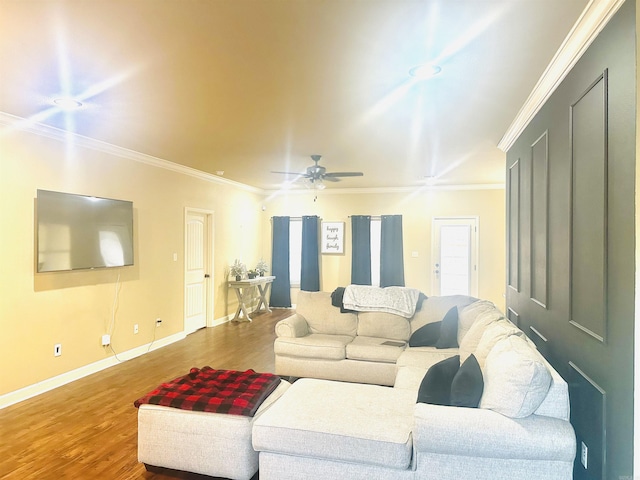 living room with ornamental molding, ceiling fan, baseboards, and wood finished floors