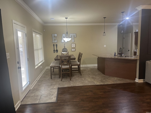 dining area with crown molding, wood finished floors, and baseboards