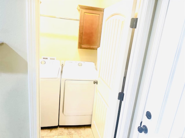 laundry room featuring cabinet space, washing machine and dryer, and light tile patterned flooring