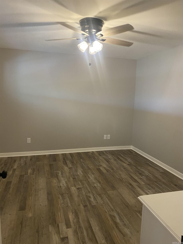 spare room featuring dark wood finished floors, baseboards, and ceiling fan