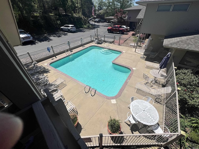 community pool featuring a patio and fence