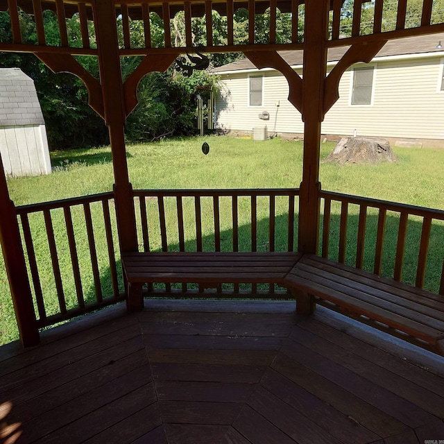 wooden terrace with an outbuilding and a lawn